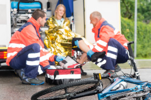 Accident bike woman get emergency help paramedics in ambulance